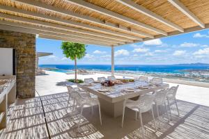 a dining table on a patio with a view of the ocean at Pasithea Horizon in Kampos Paros