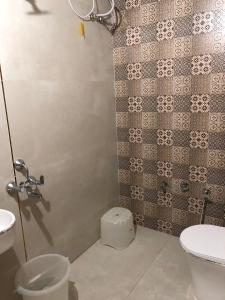 a bathroom with a toilet and a shower stall at The Imperial Regency in Porbandar