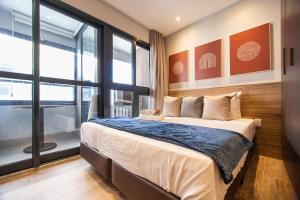 een slaapkamer met een bed en een groot raam bij 360 Soma Perdizes in Sao Paulo