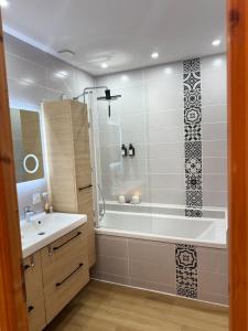 a bathroom with a tub and a sink and a shower at Maison des Passeroses in Boutiers-Saint-Trojan +34 photos