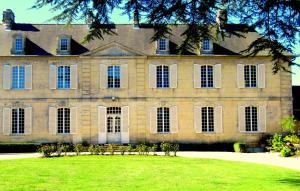 duży dom z trawnikiem przed nim w obiekcie Bed & Breakfast Chateau Les Cèdres w mieście Bretteville-lʼOrgueilleuse