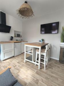 une cuisine avec une table et des chaises dans une pièce dans l'établissement Brise Nacrée proche plage, à Dunkerque 8 autres photos