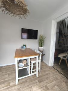 une pièce avec une table et une télévision sur un mur dans l'établissement Brise Nacrée proche plage, à Dunkerque