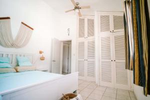 a bedroom with a bed with white walls and a ceiling at Sueño Caribeño in La Laguna