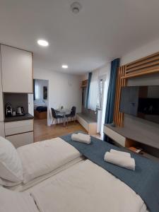 a bedroom with a large bed with two towels on it at Cappello Vendégház in Baja