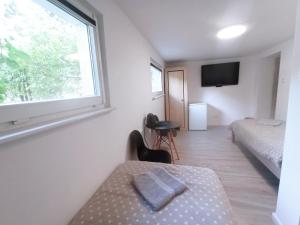 a small bedroom with a bed and a window at Sara Resort II in Wisełka