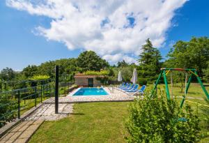 a backyard with a pool and a swing at Villa Teodora, an ideal holiday hideaway for families and friends in Krapan