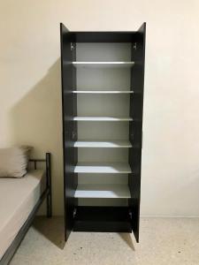 a black book shelf in a room with a bed at Private Rooms St Julians in St Julian's