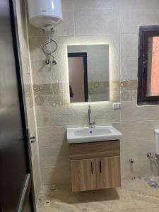 a bathroom with a sink and a mirror at شقة مبارك in Hurghada