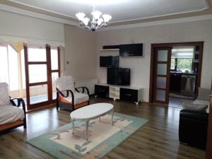 a living room with a table and chairs and a tv at Trabzon Gürbulakta kiralık villa in Trabzon
