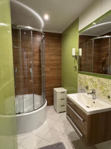 un baño con ducha y lavabo en Pokoje Meduza Łeba, en Łeba 57 fotos más