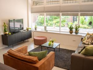 a living room with a couch and a tv at Boetiek SimonS Loft appartement centrum Brummen in Brummen