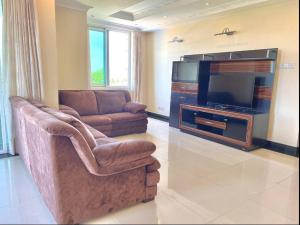 a living room with a couch and a flat screen tv at Private Room with attached bathroom at Mikocheni in Nkunjila