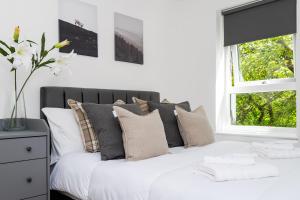 a bedroom with a white bed with pillows and a window at 2Bedroom Apartment-Free Parking in Edinburgh