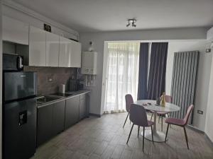 een keuken met een tafel en stoelen en een eetkamer bij Alezzi beach luxury Lidia apartment in Mamaia Nord – Năvodari