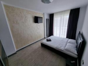 een kleine slaapkamer met een bed en een raam bij Alezzi beach luxury Lidia apartment in Mamaia Nord – Năvodari +6 foto's