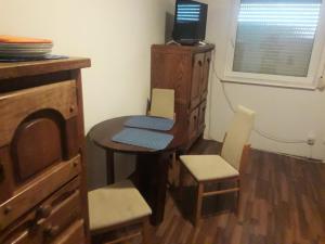 a small table and chairs in a room with a tv at Pokoje gościnne Ania in Mikoszewo +5 photos