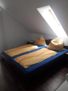 a bed with a blue sheet and pillows in a room at Pokoje gościnne Ania in Mikoszewo