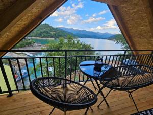 a table and chairs on a balcony with a view of a lake at Vista Lago in Jablanica