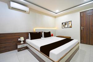 a bedroom with a large bed and a wooden door at Super Townhouse Sahayogi Nagar Near Big Bazaar in Dhanbād