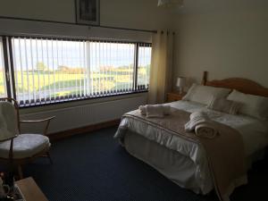 a bedroom with a bed and a window and a chair at Seawater View Accomadation - Accommodation only in Red Castle