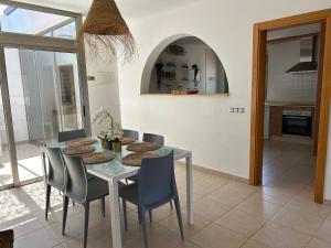 een eetkamer met een glazen tafel en stoelen bij Villa Dinateli, Salinas Golf in Caleta De Fuste