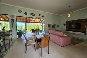 Casa Orquídeas, com piscina aquecida e vista, 3Q في بونيتو: غرفة معيشة مع طاولة وأريكة وردية