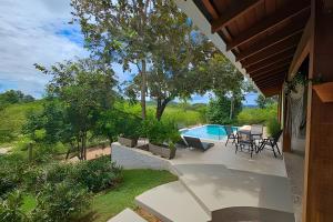 Casa Orquídeas, com piscina aquecida e vista, 3Q في بونيتو: فناء مع طاولة وكراسي ومسبح