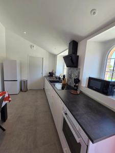 eine Küche mit einer schwarzen Arbeitsplatte in einem Raum in der Unterkunft Charmante maison familiale in Saint-Fort