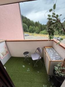 a small balcony with a chair and a table at Studio à la montagne meublé et entièrement équipé in Bellevaux