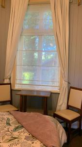 a bedroom with a window with a bed and two chairs at Hospedaje en borde río in Valdivia +10 photos