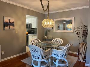 ein Esszimmer mit Glastisch und Stühlen in der Unterkunft 909 Cutter Court at The Sea Pines Resort in Hilton Head Island