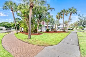 a walkway in front of a house with palm trees at Tidal Wave - In Siesta Key Village, Pet Friendly, Private Pool! in Siesta Key