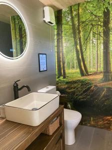 un bagno con un lavandino e un murale della foresta di Aughavannagh Yurt Glamping a Aughrim