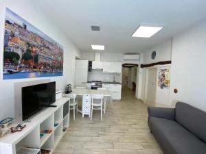 a living room with a couch and a kitchen at PinHouse in Cagliari