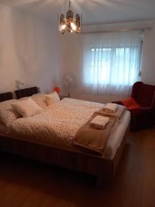 a bedroom with a large bed and a chandelier at Középső szint in Zamárdi