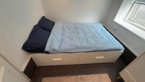 a small bed in a room with a window at Arendal Sentrum Ro in Arendal +4 photos