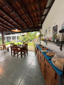 a kitchen with a counter with a table and chairs at Bahan Suites privativas - ideal para Casais in Ubatuba
