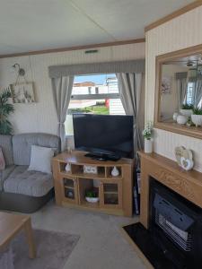 Televiisor ja/või meelelahutuskeskus majutusasutuses 48-3 Coral beach 8 berth 3 bedrooms lead person must be over 30