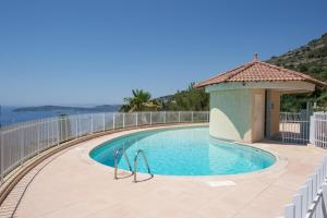 a swimming pool with a gazebo next to the water at Le Chevalier in Cap d'Ail