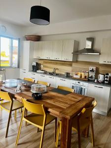 a kitchen with a wooden table and yellow chairs at B&B Mastro Mario in Rocca di Neto