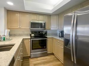 une cuisine avec des appareils en acier inoxydable et des armoires en bois dans l'établissement 1824 Beachside Tennis at The Sea Pines Resort, à Île de Hilton-Head 14 autres photos