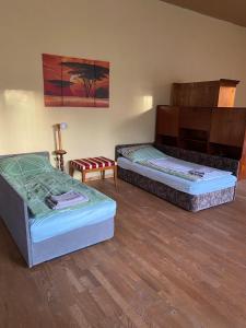 two beds in a room with wooden floors at Ferienwohnung Alte Volksschule bis 5 Personen in Raiding