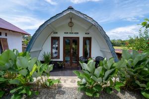 a small white building with a large doorway at Sawah Indah View Guesthouse in Timbanglawang