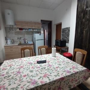 a kitchen with a table with a flowered table cloth at Prenoćište BORIK in Sanski most +9 photos