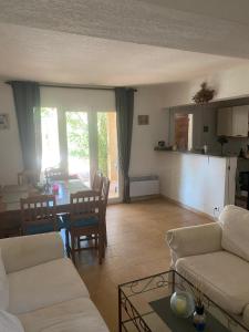 un soggiorno con un divano e un tavolo di Villa spacieuse avec piscine privee a 150 m de la plage Calvi centre a Calvi