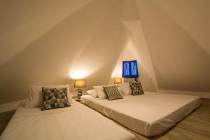 two beds in a attic bedroom with two lamps at GT Hotel Boracay in Boracay
