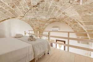 una camera con un letto di fronte a un muro di mattoni di Dimore Salentine a Felline