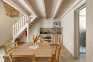 una cucina e una sala da pranzo con tavolo e sedie in legno di Dimore Salentine a Felline