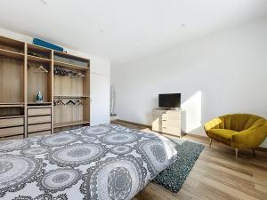 a bedroom with a large bed and a yellow chair at Maison de ville avec Jardin in Saint-Quentin